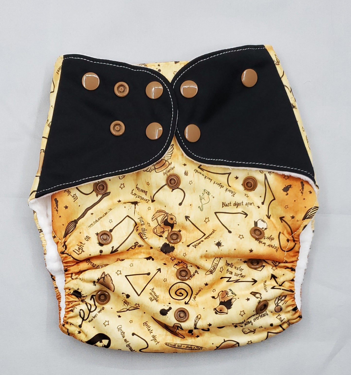 cloth diaper with extended size range of 20-60+lbs.  A modern cloth diaper with a fandom-inspired design inpired by harry potter