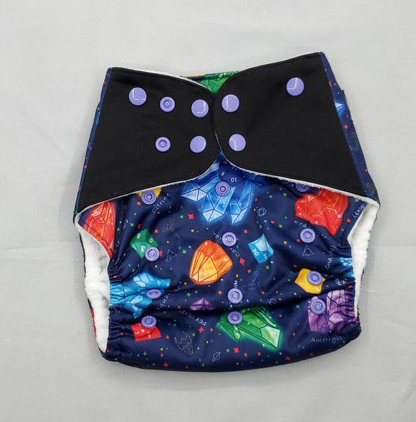 cloth diaper with extended size range of 20-60+lbs.  A modern cloth diaper with a fandom-inspired design featuring polyhedral dice, roleplaying classes, and healing crystals